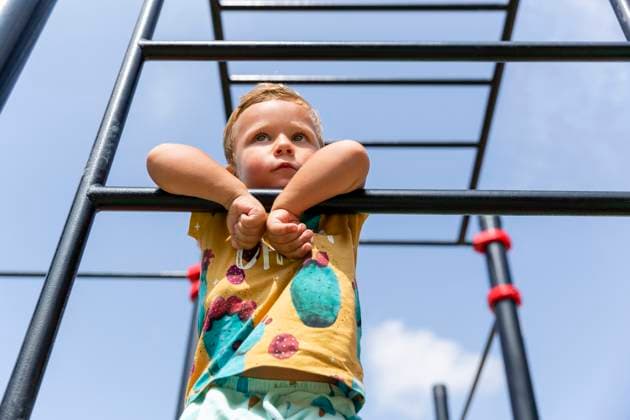 Creative Highlights Symbolbilder Cute boy leaning on monkey bar at playground model released, Symbolfoto, MEGF01087