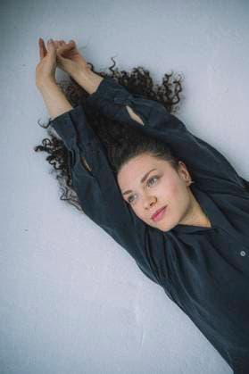 Creative Highlights Symbolbilder Thoughtful curly haired woman stretching arms on bed at home model released, Symbolfoto property released, ANAF04347