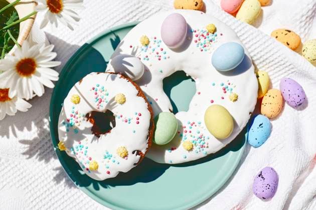 Easter doughnuts decorated with colorful chocolate eggs on table, CATF00555