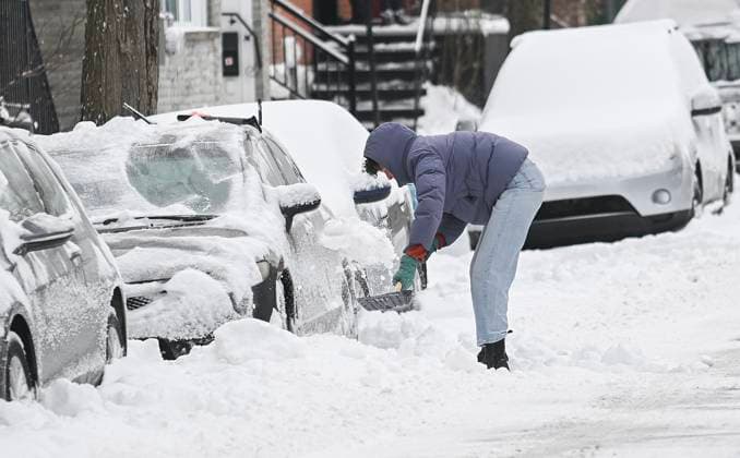 December 24, 2024, Montreal, Pq, Canada: A person clears snow from around a car following a snowstorm in Montreal, Tuesday, December 24, 2024. Montreal Canada  - ZUMAc35_ 20241224_zaf_c35_005 Copyright: xGrahamxHughesx