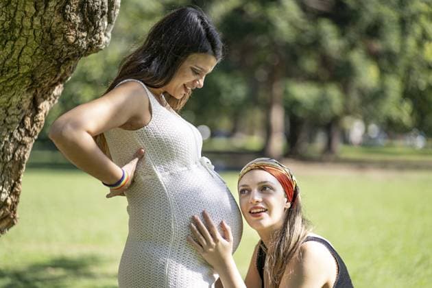 Lateinamerikanerin hört dem Bauch seiner schönen schwangeren Freundin zu Latin woman listening to his beautiful pregnant girlfriend s tummy Copyright: imageBROKER MarianoxGaspar ibxmog11958876.jpg ,model released, Symbolfoto ,property released