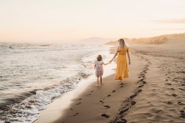 Creative Highlights Symbolbilder Back view mother and daughter holding hands at beach sunset Marbella, Andalusia, Spain CR_TANI241228-1601498-01 ,model released, Symbolfoto