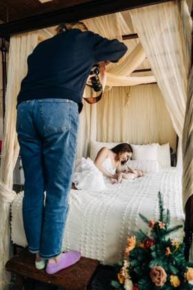 hotographer capturing a mother playing with her baby on a canopy bed North Andover, Massachusetts, United States CR_FKNH241229-1610984-01 ,model released, Symbolfoto