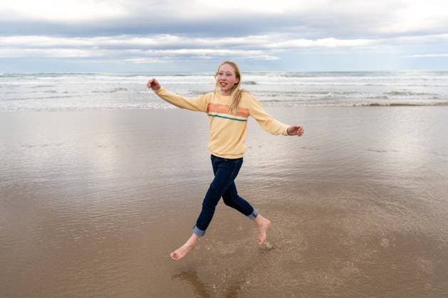 Creative Highlights Symbolbilder Happy girl skipping at beach Ocean Beach, Hawke s Bay, New Zealand CR_JUCR241229-1616641-01 ,model released, Symbolfoto