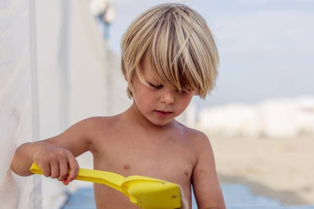 Creative Highlights Symbolbilder Curious Boy Focused on Sand Play with Yellow Shovel Knokke-Heist, Flanders, Belgium R_DIME241230G-1610619-01 ,model released, Symbolfoto