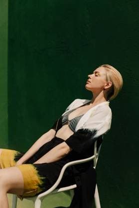 Creative Highlights Symbolbilder RECORD DATE NOT STATED Stylish young woman in a dress poses against a vibrant green backdrop 28318483