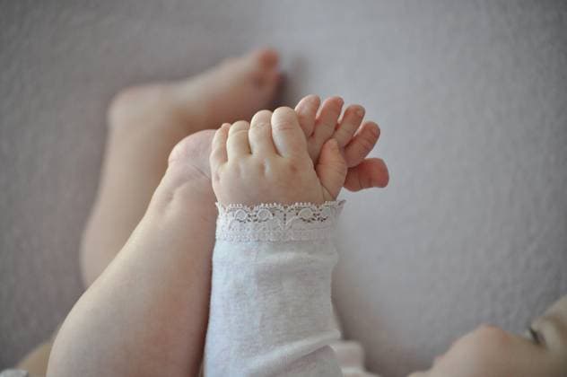 Creative Highlights Symbolbilder A baby enjoys playing with their own feet in a cozy space Stockholm, Stockholm County, Sweden R_ZTGJ250110-1625092-01 ,model released, Symbolfoto