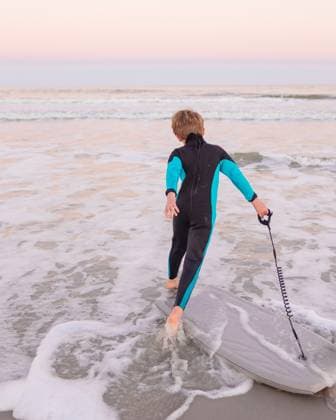 Creative Highlights Symbolbilder boy in wetsuit with boogie board running to the ocean Atlantic Beach, Florida, United States R_HZPG250111-1626668-01 ,model released, Symbolfoto