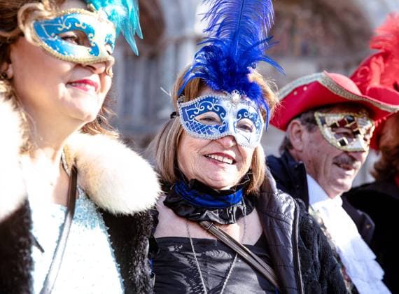 Festive elderly caucasian group in colorful venetian masks at ca Venice, Veneto, Italy R_GVYI250112A-1626504-01 EDITORIAL USE ONLY