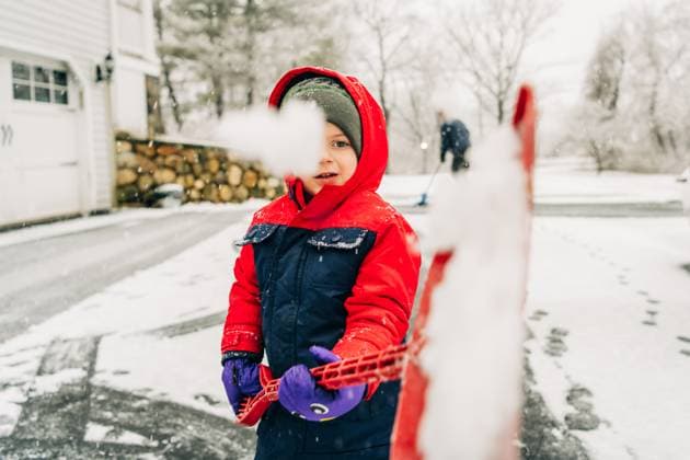 Creative Highlights Symbolbilder Child in red coat and beanie holding snow-filled shovel outdoors North Andover, Massachusetts, United States R_FKNH250112B-1622990-01 ,model released, Symbolfoto