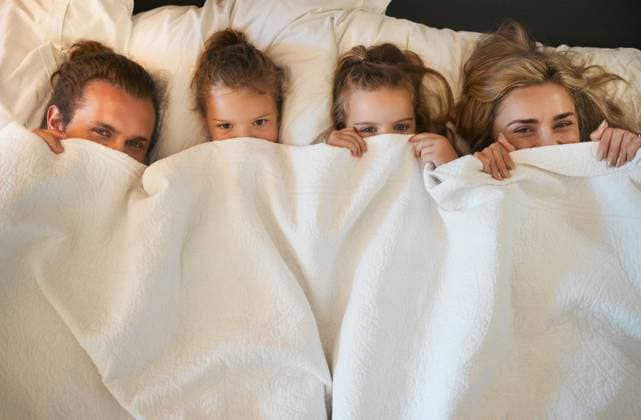 Creative Highlights Symbolbilder Parents, children and hide in blanket for relax, lazy morning and comfort in bed. Above, happy family and portrait in home with cover, playful and bonding on weekend with rest, care or childhood game. model released property released Copyright: xwww.peopleimage.comx