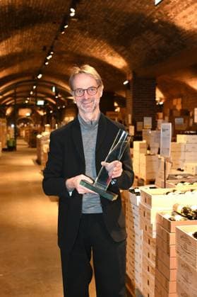 Andreas Brensing, Geschäftsführer Kölner Weinkeller posieri mit Thophäe bei der Veranstaltung der Kölner Weinkeller wurde vom Fachmagazin Weinwirtschaft zum Weinhändler des Jahres 2025 gekürt