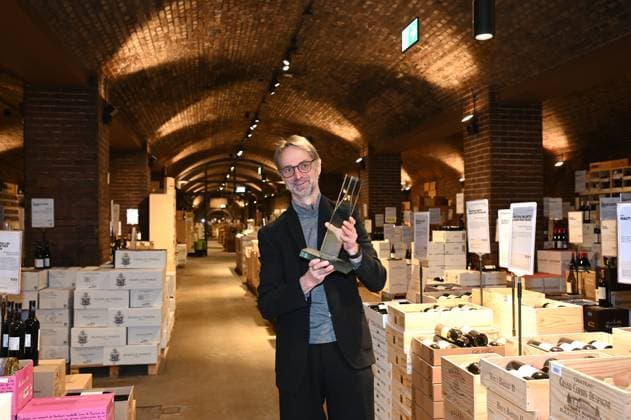 Andreas Brensing, Geschäftsführer Kölner Weinkeller posieri mit Thophäe bei der Veranstaltung der Kölner Weinkeller wurde vom Fachmagazin Weinwirtschaft zum Weinhändler des Jahres 2025 gekürt