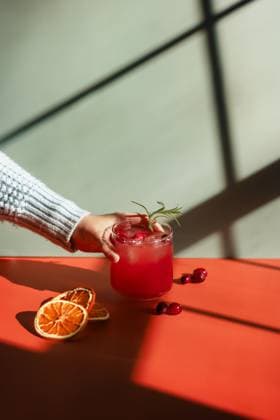 Hand holding a cranberry drink in front of colorful background Tulsa, Oklahoma, United States CR_KRRY250117-1630458-01