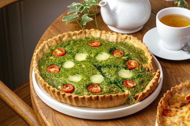 quiche with tomatoes and spinach on a plate R_KUAL250119-1540516-01