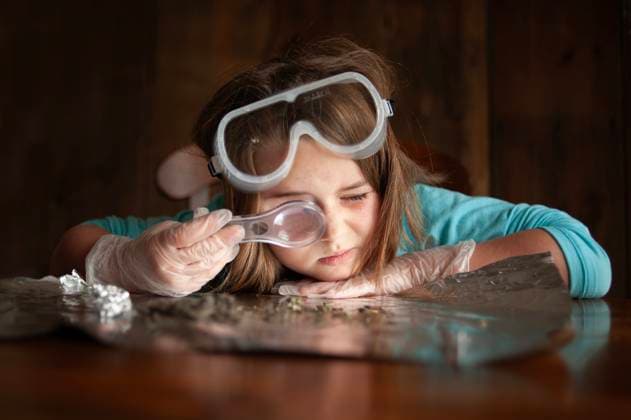 Young female girl looking through magnifying glass with goggles Wooster, Ohio, United States CR_JOKU25012188-1635515-01 ,model released, Symbolfoto