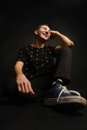 A cheerful young man posing in trendy clothes against a dark backdrop Saint Petersburg, Saint Petersburg, Russia CR_KNCD250121-1635427-01 ,model released, Symbolfoto