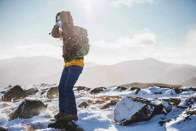 warmly dressed woman with camera hiking in extreme cold in Maine Carrabassett Valley, Maine, United States CR_SSNF250121A-1630151-01 ,model released, Symbolfoto