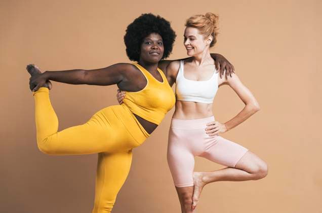 Confident young woman with arm around smiling friend against beige background model released, Symbolfoto, OIPF03750