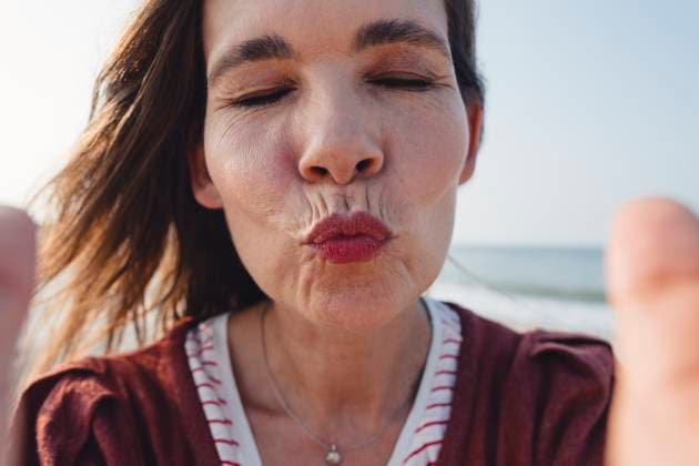 Beautiful woman puckering lips at beach model released, Symbolfoto, KNSF10517