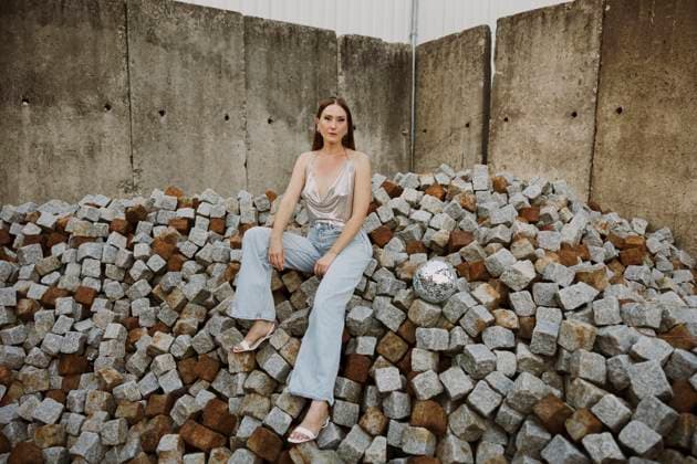 Woman sitting on cement bricks with disco ball model released, Symbolfoto, MCHF00418