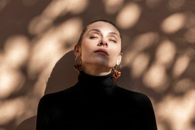 Woman wearing black turtle neck sweater with eyes closed in front of wall model released, Symbolfoto, LMCF02003
