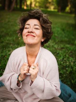 Smiling woman with eyes closed sitting in park model released, Symbolfoto, IEF00826