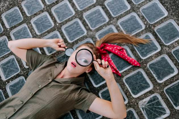 Woman lying on floor with magnifying glass model released, Symbolfoto, MCHF00441