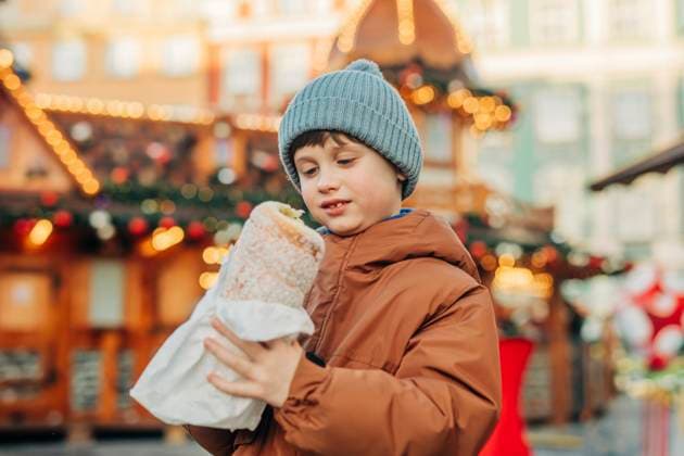 Boy in blue knit hat holding trdelnik at market during Christmas model released, Symbolfoto, VSNF02763