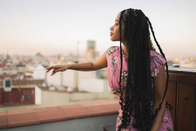 Contemplative woman sitting on building terrace model released, Symbolfoto property released, ALZF00935