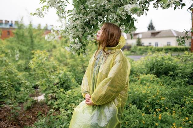 Young woman wearing raincoat at back yard of house model released, Symbolfoto, VCF00549