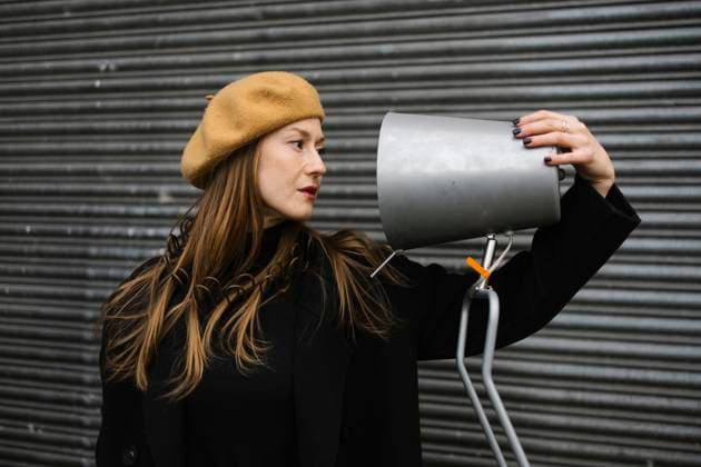 Woman looking at old metal lamp near corrugated iron model released, Symbolfoto, MCHF00465