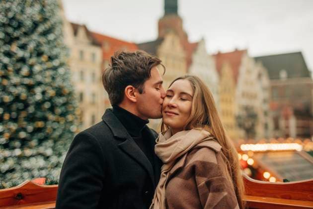 Affectionate young man kissing girlfriend at Christmas market model released, Symbolfoto, VSNF02800