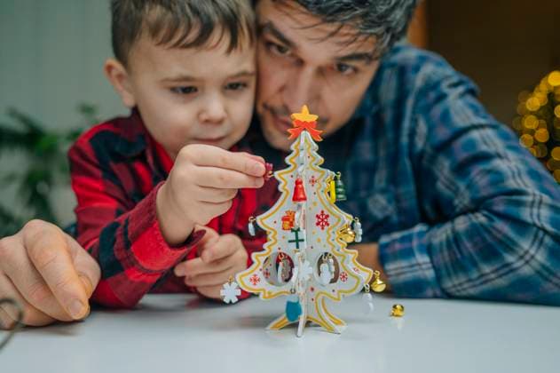 Father and son decorating paper Christmas tree at home model released, Symbolfoto property released, ANAF04412