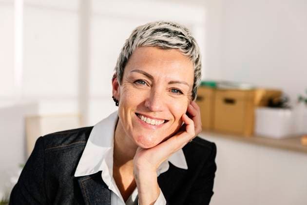 Smiling businesswoman with hand on chin at office model released, Symbolfoto property released, XLGF03473
