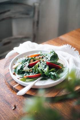 A wholesome dish featuring fresh spinach leaves, crisp apple slices, and crunchy pecan nuts, garnished with sesame seeds, served on a white plate. Model Released CamilaMacedo_ID26018_750702_003 Copyright: xCamilaxMacedox RECORD DATE NOT STATED