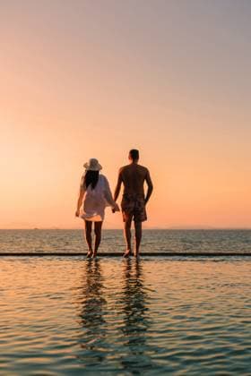 Romantischer Spaziergang bei Sonnenuntergang auf der Insel Koh Munnork in Rayong, Thailand A couple of men and women walk hand in hand along the edge of a tranquil infinity pool at Koh Munnork Island, soaking in the breathtaking sunset over the serene waters of Thailand. ,model released, Symbolfoto Copyright: xZoonar.com FokkexBaarssenx 22679617 ,model released, Symbolfoto ,property released