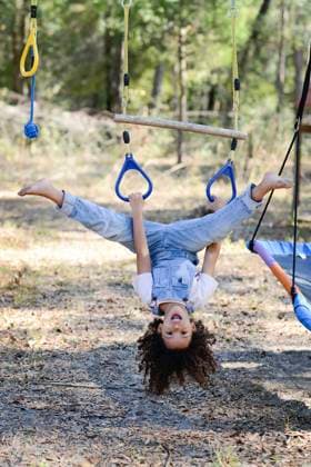 IMAGO Creative, Sommer, Sommertage im Garten A playful child in overalls hangs upside down on a rope swing ou United States, Florida, Inverness R_YWQX250124-1637055-01 ,model released, Symbolfoto