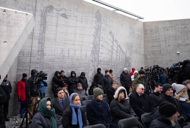 January 27, 2025, Ottawa, On, Canada: In front of a wall with a mural of a concentration camp, people listen to a speaker during a ceremony at the National Holocaust Monument, Monday, Jan 27, 2025 in Ottawa. Ottawa Canada  - ZUMAc35_ 20250127_zaf_c35_055 Copyright: xAdrianxWyldx