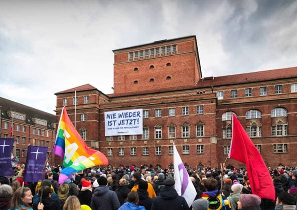 News Themen der Woche KW05 News Bilder des Tages Kiel, 27.01.2025, Demonstration und Menschenkette für die Demokratie zum bundesweiten Holocaust - Gedenktag In der Menschenmenge bei der Demonstration zum Holocaust Gedenktag 2025. Im Vordergrund Flaggen der evangelischen Kirche, eine Regenbogenflagge und andere. Im Hintergrund an der Wand des Kieler Opernaus hängt ein Transparent mit dem Motto der Demonstration Nie wieder ist jetzt Kiel Rathausplatz Schleswig-Holstein Deutschland *** Kiel, 27 01 2025, Demonstration and human chain for democracy on the nationwide Holocaust Remembrance Day In the crowd at the demonstration on Holocaust Remembrance Day 2025 In the foreground flags of the Protestant church, a rainbow flag and others In the background on the wall of the Kiel Opera House han