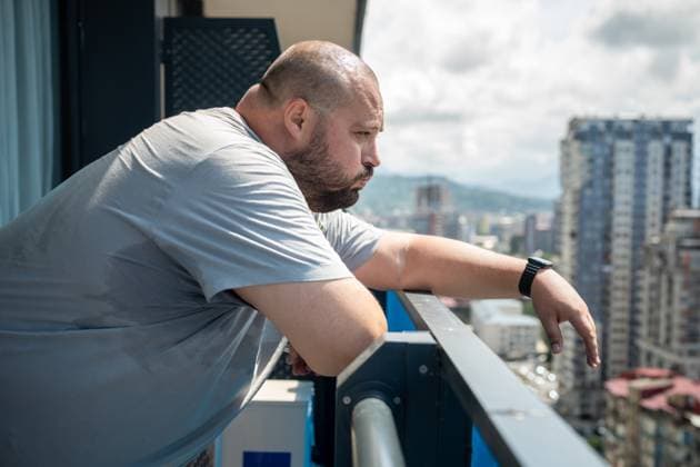 IMAGO Creative, Jahreszeit Sommer, Hitze Übergewichtiger Mann, der sich bei sommerlicher Hitze schlecht fühlt, steht auf einem Balkon und schaut auf die Straße. Overweight man feeling bad from heat in summer standing on balcony looking at street in summer. High sweating, hyperhidrosis, obesity, heaviness from hot weather high humidity, excess body weight. ,model released, Symbolfoto Copyright: xZoonar.com DmitriixMarchenkox 22719893 ,model released, Symbolfoto ,property released