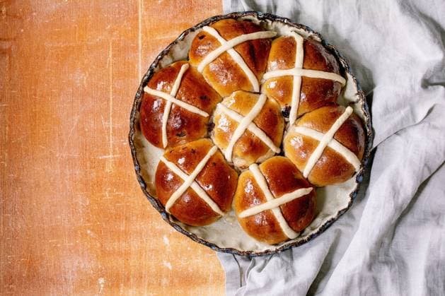Hausgemachte traditionelle Osterbrötchen auf Keramikschale Homemade Easter traditional hot cross buns on ceramic dish over orange stone background with grey linen cloth. Flat lay, copy space Copyright: xZoonar.com NATASHAxBREENx 22727608