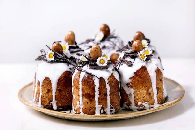 Hausgemachter traditioneller orthodoxer Osterkuchen traditioneller Kulich Homemade traditionla Easter kulich cake with chocolate nests and eggs on ceramic plate over white texture background. Traditional ortodox easter Russian Ukrainian bake Copyright: xZoonar.com NATASHAxBREENx 22727611