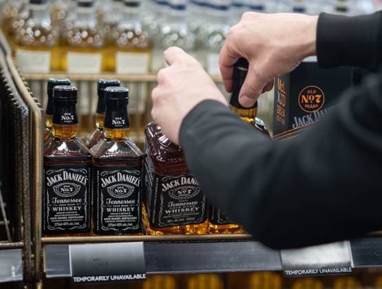 February 2, 2025, Vancouver, Bc, CANADA: A B.C. Liquor Store employee demonstrates removing bottles of American whiskey for media before a news conference in Vancouver, B.C., Sunday, Feb. 2, 2025. Vancouver CANADA  - ZUMAc35_ 20250202_zaf_c35_115 Copyright: xEthanxCairnsx