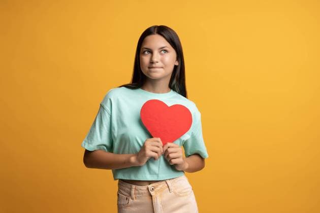 Nettes brünettes Teenie-Mädchen, das ein rotes Papierherz in den Händen hält und auf gelbem Hintergrund posiert. Nettes brünettes Teenie-Mädchen, das ein rotes Papierherz in den Händen hält und auf gelbem Hintergrund posiert. ,model released, Symbolfoto Copyright: xZoonar.com DmitriixMarchenkox 22733419 ,model released, Symbolfoto ,property released