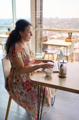 a 60s woman drinking nettle tea in modern coworking office during lunch break Model Released VictoriaAntre_ID25251_730421_030 Copyright: xx