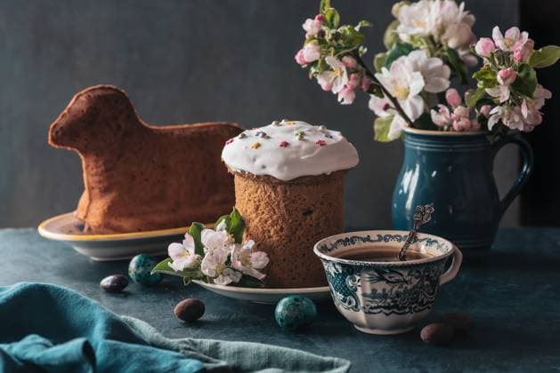 Gedeckter Ostertisch mit Osterkuchen Easter table setting with easter cake in the shape of a lamb, spring flowers, eggs and cup of coffee Copyright: xZoonar.com DidoraxGannax 22742954
