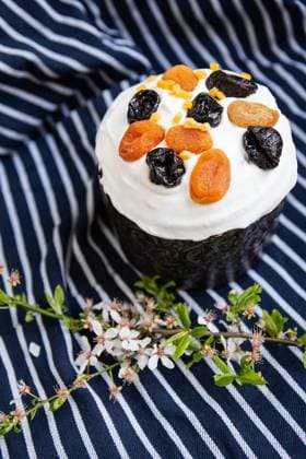 Easter cake, decorated with dried apricots and prunes, stands on a striped blue apron, a flowering branch. Easter religious holiday concept , 49605914.jpg, Easter, cake, holiday, tradition, traditional, decoration, multi colored, eggs, spring, celebration, watercolor, religion, food, icing, green, flower, prune, dried apricots, cream, sweet, festive, delicious, white, baked, pastry shops products, symbol, culture, table, sugar, dessert, bread, christianity, close up, decorative, bakery, glazed, biscuit, blue, colorful, season, pink, homemade, nobody, wooden, flora, plant, sand cover, brown, apron RECORD DATE NOT STATED