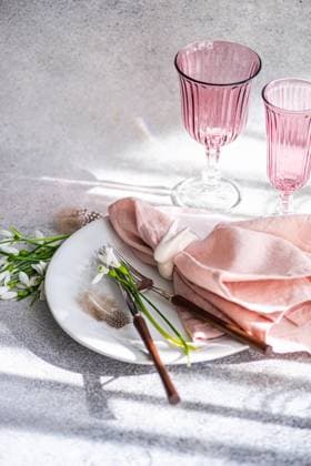 IMAGO Creative, Frühling, Licht und Sonne A tasteful arrangement on a shadow-dappled table featuring pink glassware, delicate snowdrops on a plate, and a soft pink napkin, creating a serene and inviting springtime meal setting. Model Released AnnaBogush_ID26489_764315_018 Copyright: xAnnaxBogushx