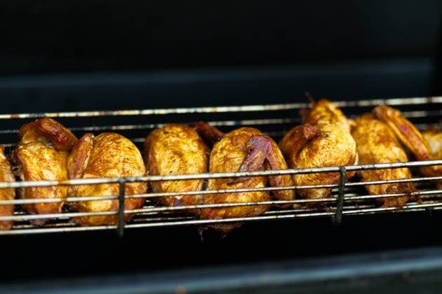 Juicy grilled chickens cooking on a metal rack, highlighting the vibrant street food scene at an outdoor fair. Model Released Ptashkimenko_ID26235_756766_005 Copyright: xPtashkimenkox RECORD DATE NOT STATED